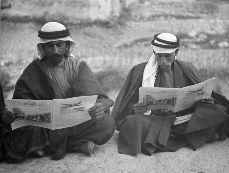 Palestinian Arab men reading the Huna Al-Quds magazine, 1940